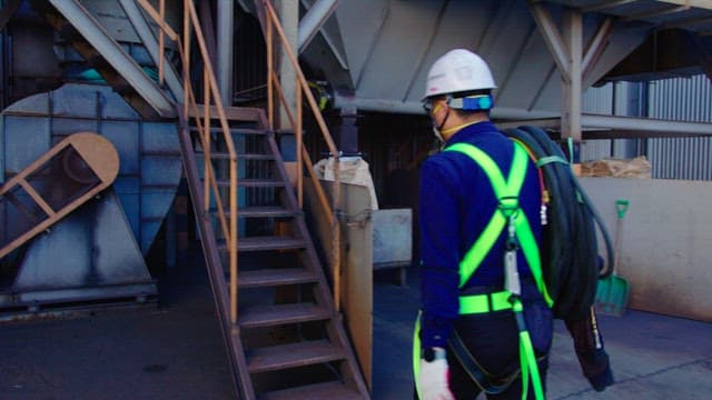 Worker Climbing Stairs at an Industrial Site