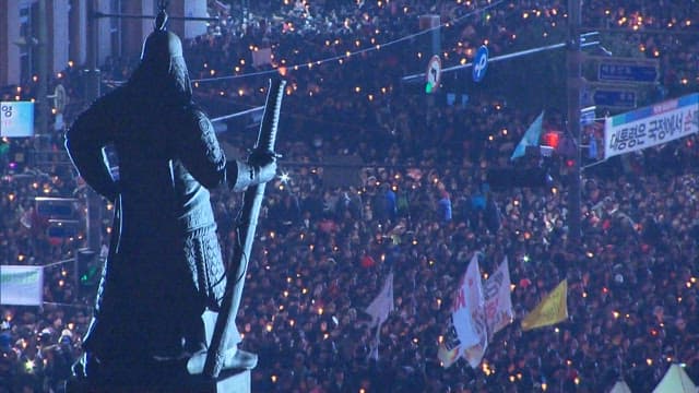 Silhouette of a Statue Overlooking a Crowd