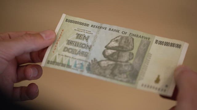 Hand holding a ten trillion Zimbabwean dollar bill