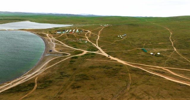 Vast green plains with yurts