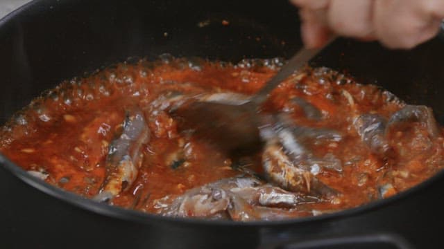 Fresh anchovies simmered with red sauce in a pot