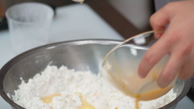 Mixing baking ingredients such as flour and eggs in a bowl