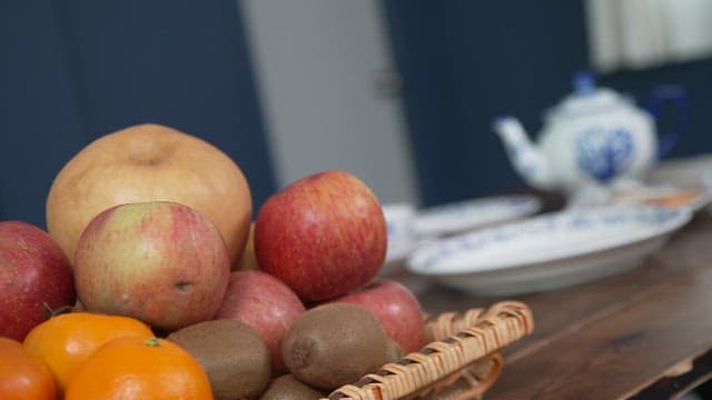 Fruits and tea set on a wooden table in the dining room