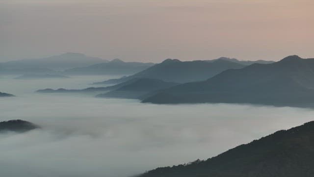 Sky Colored by Sunrise over Foggy Mountains