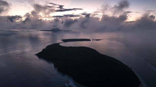 Island at dawn with clouds and ocean