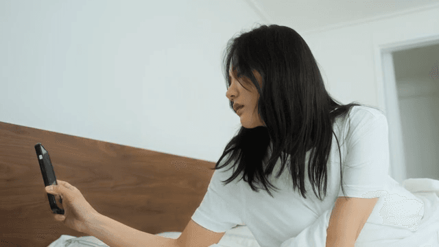 Woman Checking Her Phone After Waking Up