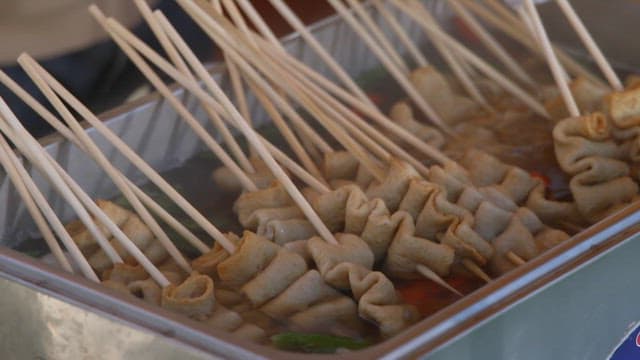 Skewered fishcakes being cooked in hot broth