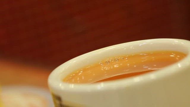Steaming Hot Beverage Served with a Butter Scones