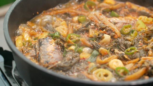 Appetizing braised mackerel with dried radish greens simmering in a pot
