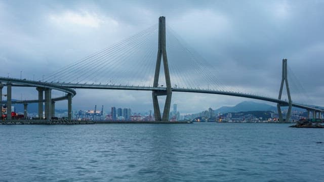 Busy Busanhangdaegyo Bridge and serene sea from evening to night at cloudy day