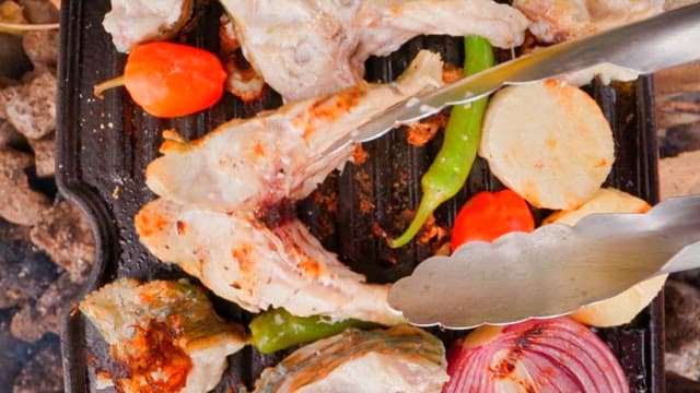Fresh parrotfish and colorful vegetables grilled on an outdoor barbecue grill