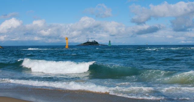 Serene Seashore with Distant Island and Lighthouses
