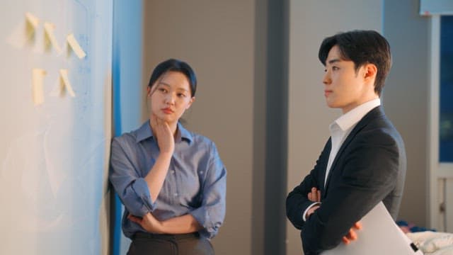 Two colleagues discussing at a whiteboard
