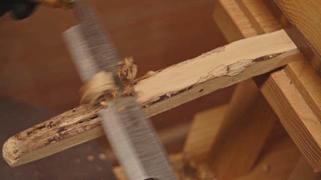 Wood being carved with a hand tool