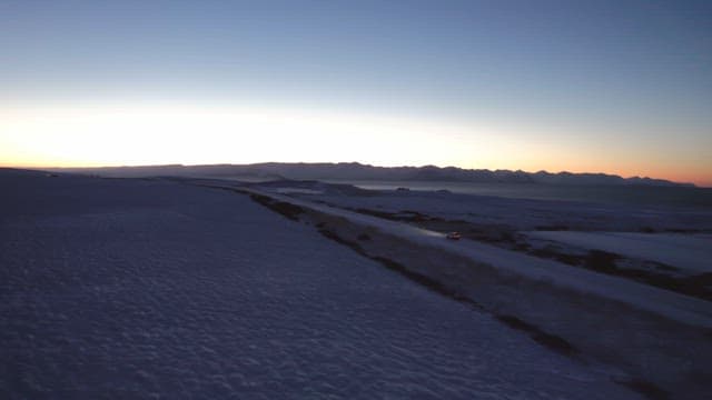 Car driving on a snowy road at dawn