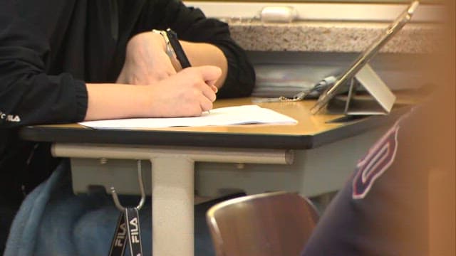 Students Studyinh with Workbooks and Tablets in the Classroom