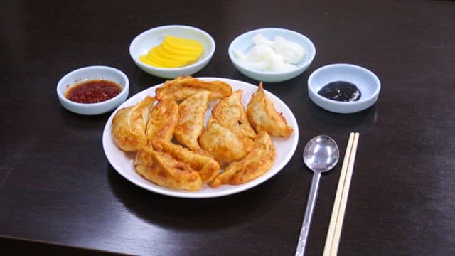 Crispy dumplings plated with radish and onion