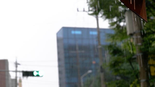 Traffic lights and buildings seen blurry on a rainy day