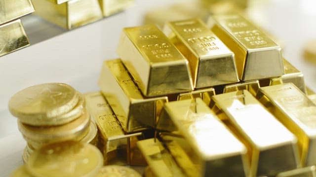 Shiny gold bars and stacked coins