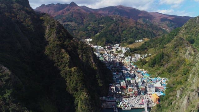 Aerial View of Coastal Town Nestled in Mountains