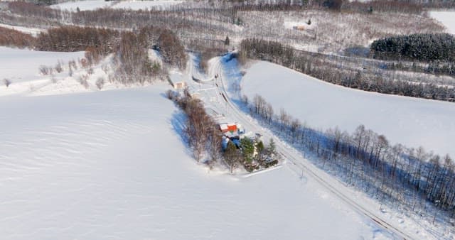 Aerial View of Snow-covered Landscape and Road