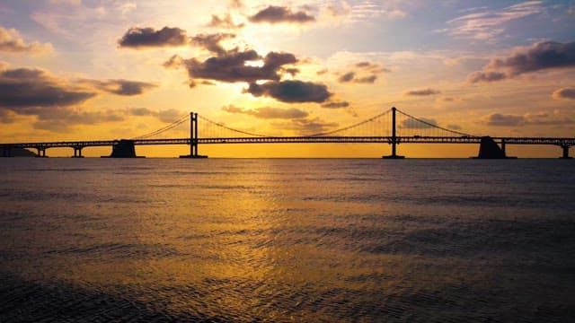 Sunset over a Tranquil Sea with a Bridge