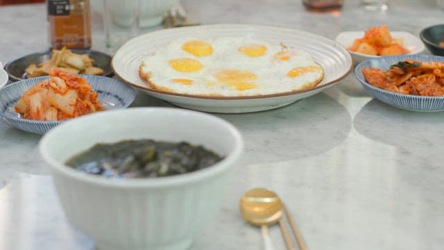 Table with fried eggs, kimchi, and laver soup