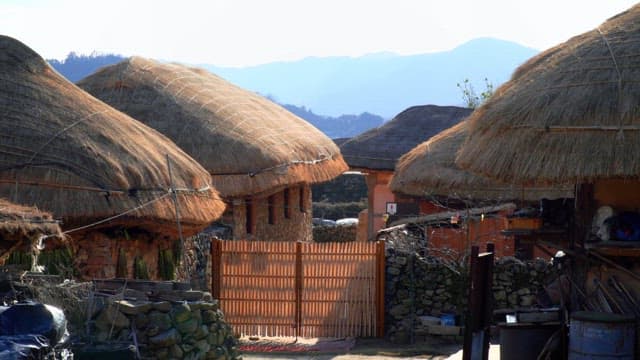 Rural village with thatched-roof houses on a sunny day