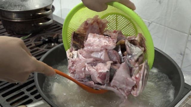 Cooking fish guts in a large pot in the kitchen
