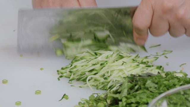 Cutting green vegetables on a cutting board