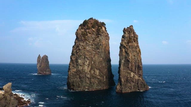 Seaside cliffs standing tall against the deep blue ocean under a clear sky