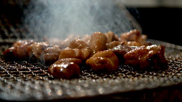 Seasoned pork intestines sizzling on a grill