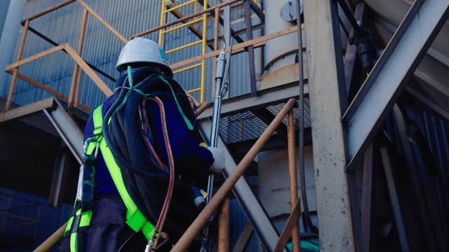 Worker Climbing Stairs at an Industrial Site
