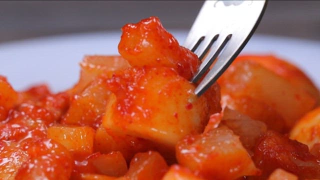 Bite of delicious and spicy tteokbokki with fork