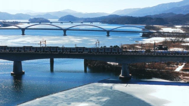 Train Crossing a Bridge in a Winter Landscape