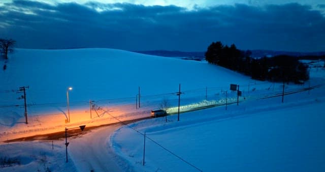 Twilight Snowscape with Passing Car