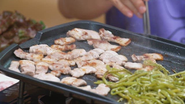 Pork belly and sweet potato stem sizzling on an iron plate