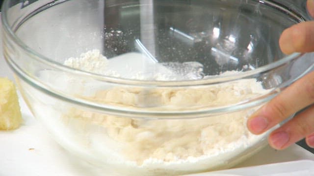 Mixing potato batter in a glass bowl