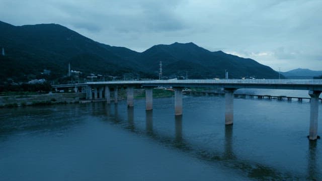Bridge with cars passing over a river with city skyline