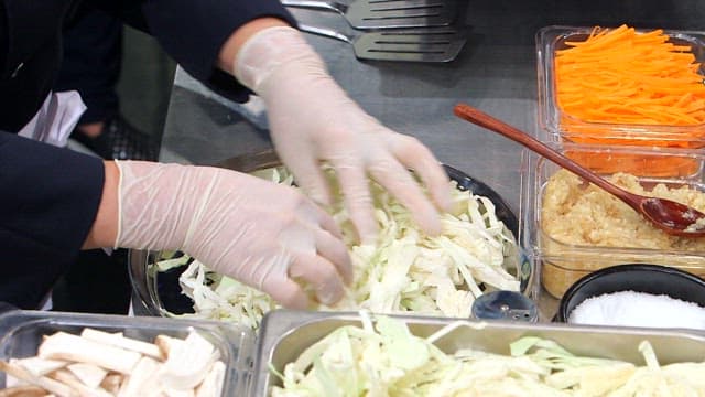 Preparing the dish by putting the sundae, vegetables, and noodles in a pot