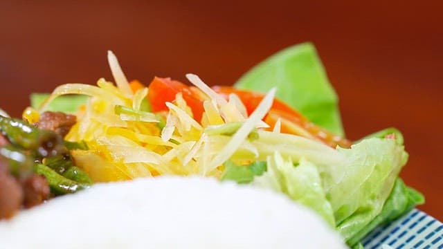 A plate of rice with stir-fried beef and vegetables