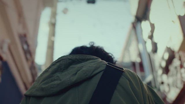 Nack of a person going up the stairs in a sunny alley