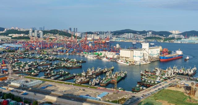 Busy harbor with cargo ships and cityscape in Busan