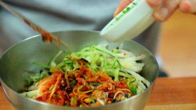Stirring cold raw fish soup with chopsticks