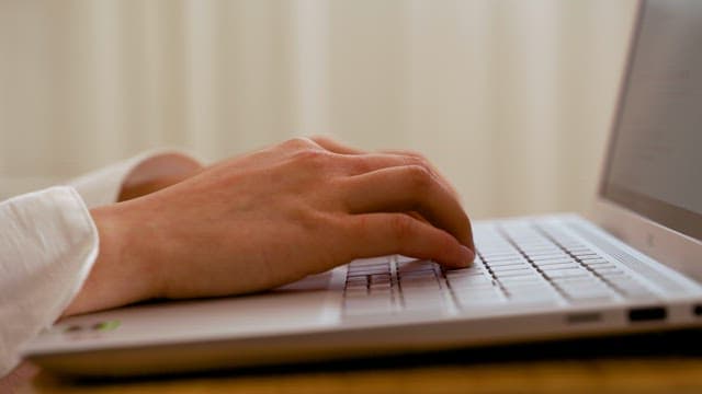 Person Typing on Laptop Keyboard