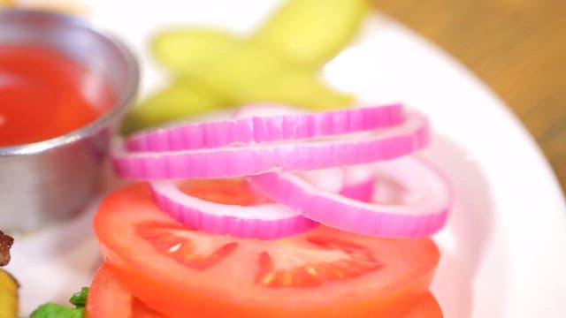 Juicy cheeseburger plated with fresh tomatoes and onions