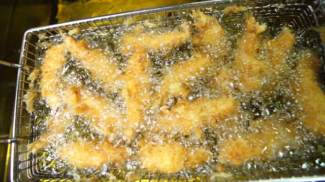 Fried boneless chicken sizzling in hot oil