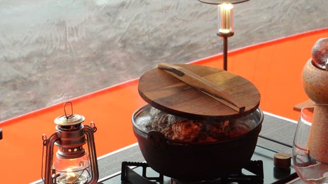 Fresh oysters prepared in a pot on a gas stove in tent