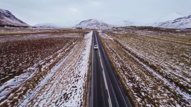 Car driving on a road with snowy mountains