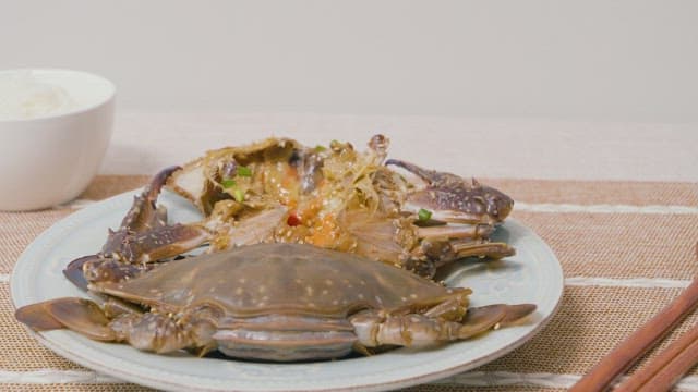 Picking up Savory Crab Dish with Tongs